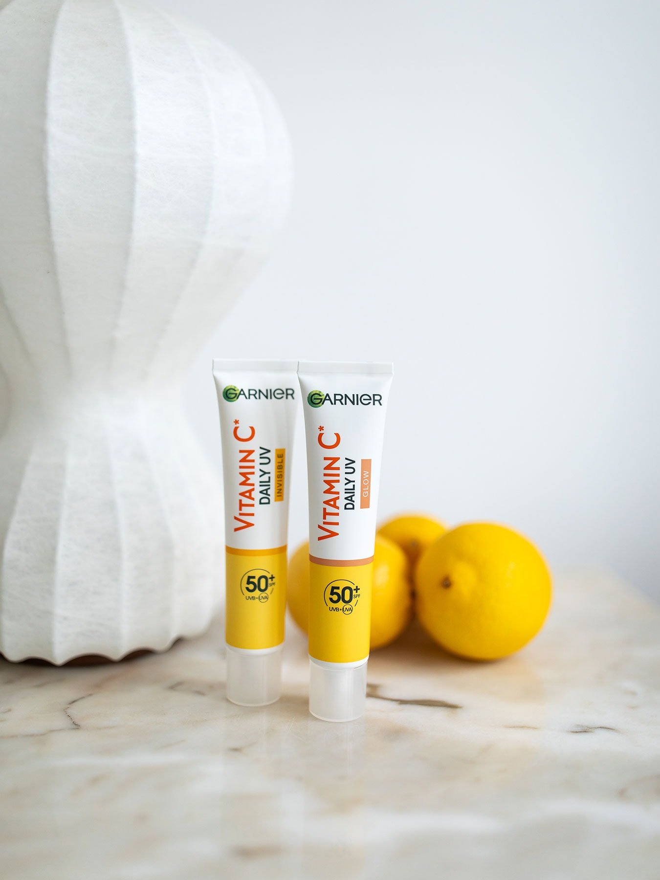Zwei Packungen SkinActive Vitamin C Tägliches Sonnenfluid Invisible mit LSF 50+ und einigen Zitronen