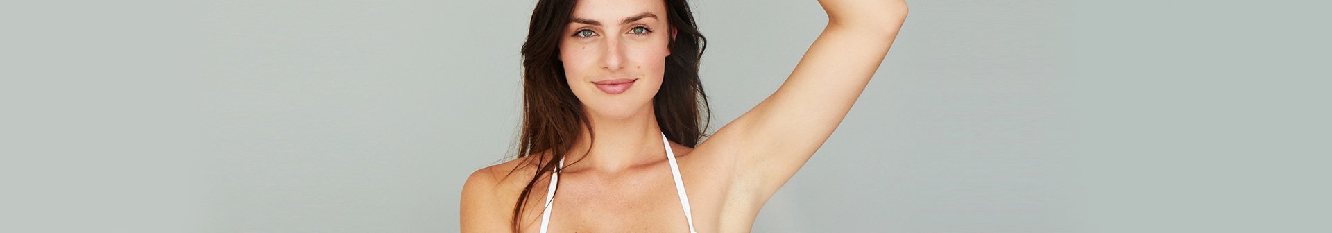 Frau hebt Arm und zeigt Achseln