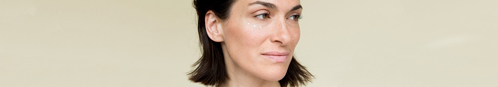 Frau mit aufgetragener Augencreme