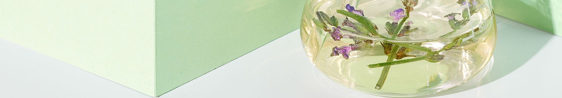 Lavendelblüten schwimmen in mit Öl gefüllten Glas