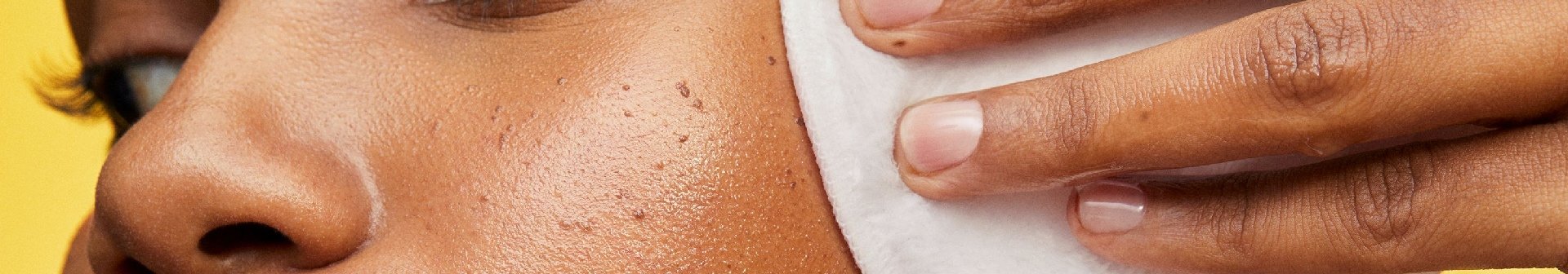 Junge Frau reinigt ihr Gesicht mit einem wiederverwendbaren Wattepad