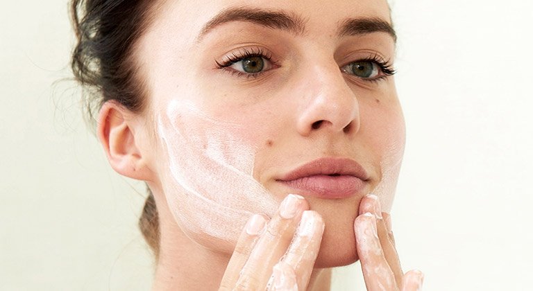 Frau trägt Creme auf
