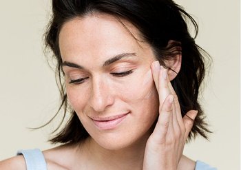 Frau berührt zufrieden ihre Haut