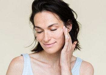 Frau berührt zufrieden ihre Haut