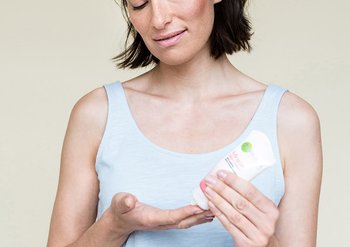 Frau drückt Creme auf ihre Hand