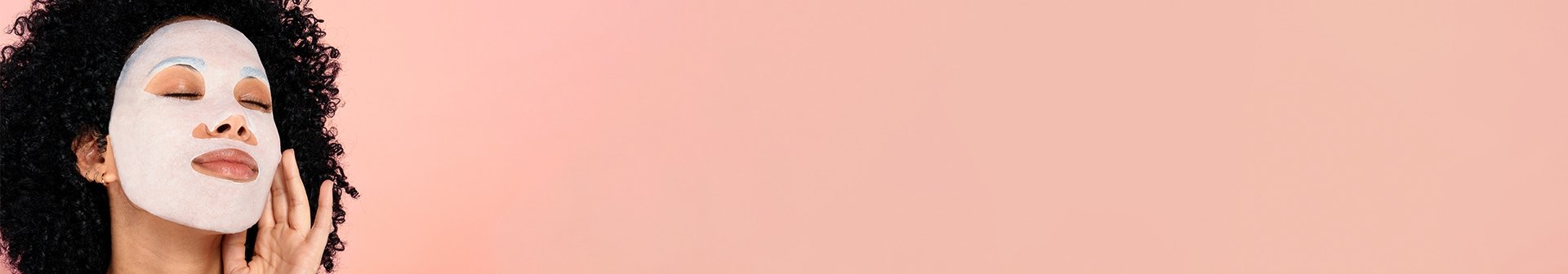 Eine junge Frau mit Gesichtsmaske und lockigen dunklen Haaren