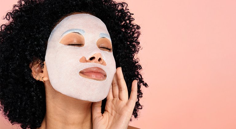 Eine junge Frau mit Gesichtsmaske und lockigen dunklen Haaren