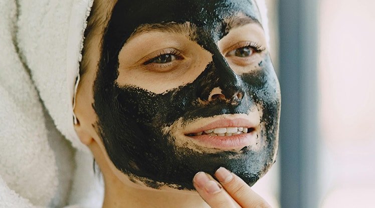 Eine Frau trägt eine Gesichtsmaske auf