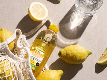 Garnier SkinActive Mizellen Reinigungswasser mit Vitamin C umgeben von Zitronen.