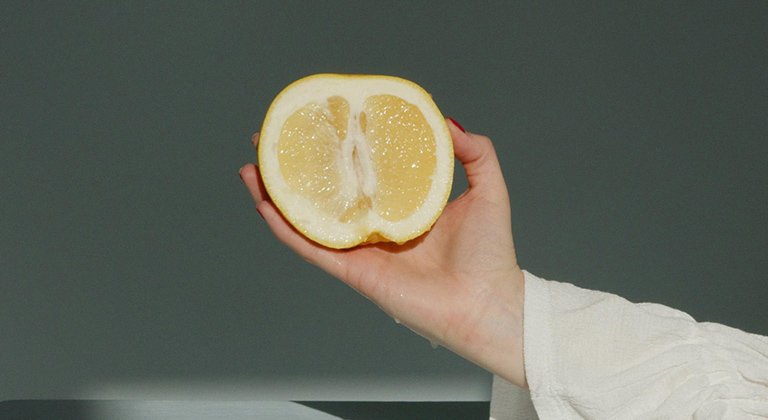 Eine aufgeschittende Zitrone wir von einer Hand gehalten