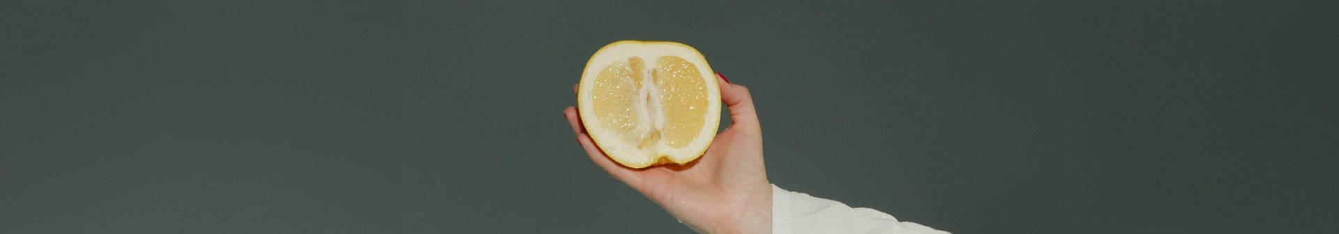 Eine aufgeschittende Zitrone wir von einer Hand gehalten