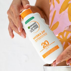 Frau hält eine Sonnencreme in ihren Händen