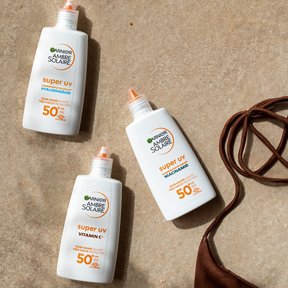 Sonnencremeprodukte liegen im Sand