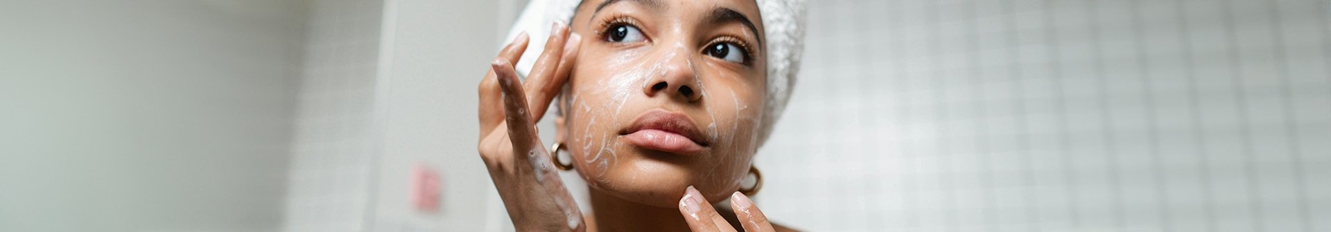 Frau beim Auftragen einer Gesichtsmaske gegen Pickel