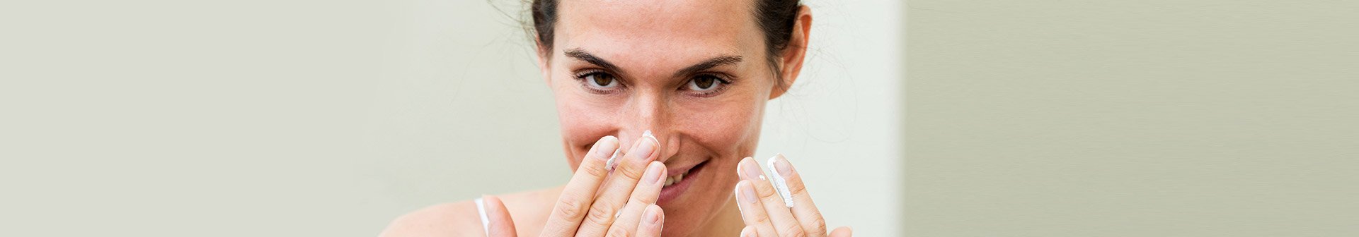 Frau berührt lächelnd ihre Haut