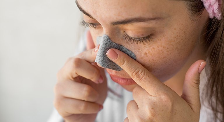 Eine junge Frau deckt ihre Nase ab