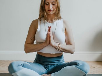 Eine junge Frau im Lotussitz bei der Meditation
