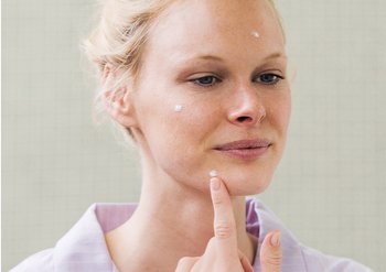 Frau zeigt auf ihre Haut