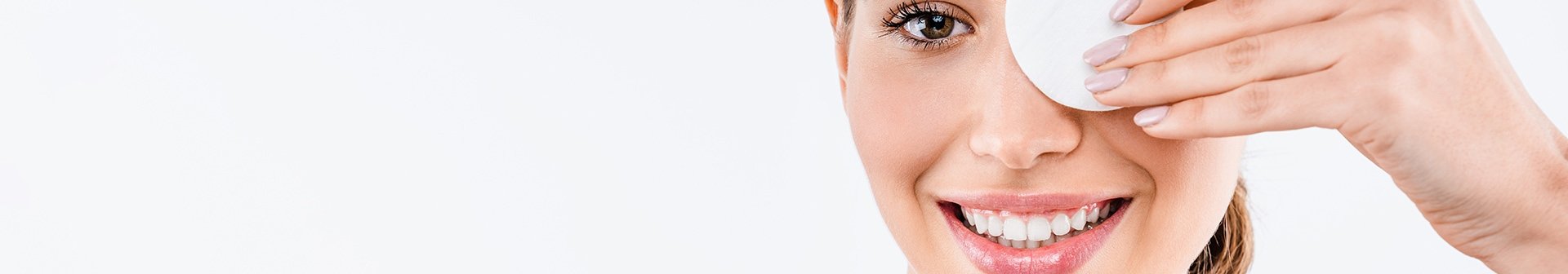 Junge Frau hält sich ein Reinigungspad vor ihr linkes Auge