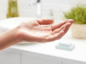 Hand mit Mizellenwasser-Textur in der Handfläche – Anwendung in der täglichen Gesichtspflegeroutine