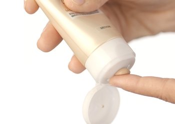 Hände tragen Creme auf