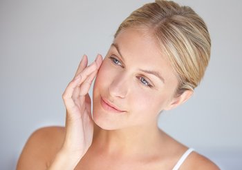 Lächelnde Frau trägt Creme auf