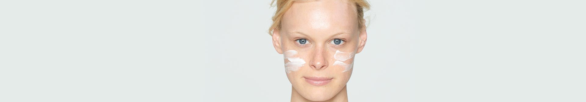 Frau mit Creme auf den Wangen