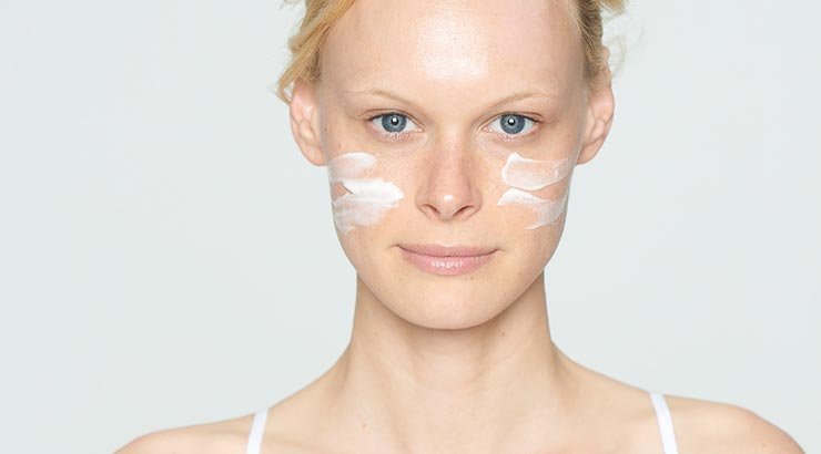 Frau mit Creme auf den Wangen