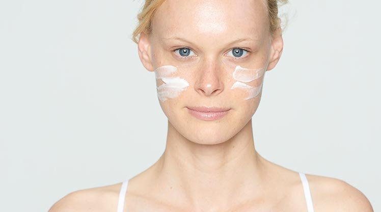 Frau mit Creme auf den Wangen
