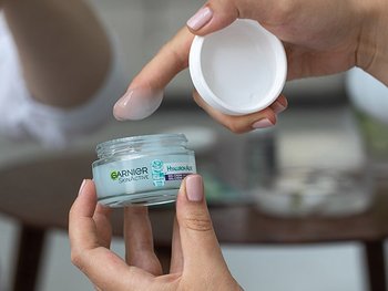Eine gepflegte Hand hat Garnier SkinActive Creme auf ihrem Zeigefinger