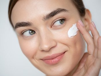 Eine Frau cremt ihr Gesicht ein