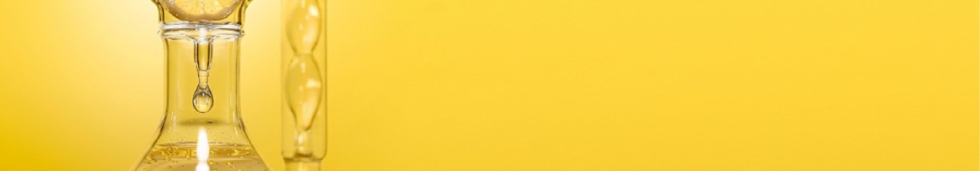 Visualisierung von Vitamin C für Anti-Aging, Zitronen in einem Behältnis aus Glas vor gelbem Hintergrund
