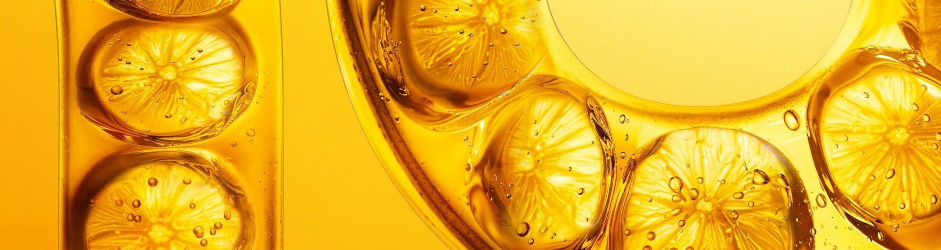 Visualisierung von Vitamin-C-Derivat in Form von Zitronenscheiben in Flüssigkeit vor gelbem Hintergrund