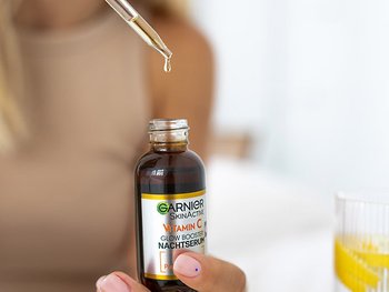 Mit einer Pipette wird Vitamin C wird aus einem Fläschchen etwas Nachtserum entnommen