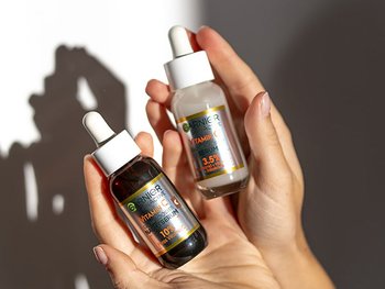 Die beiden Produkte Vitamin C Nachtserum und Serum in zwei Händen gehalten