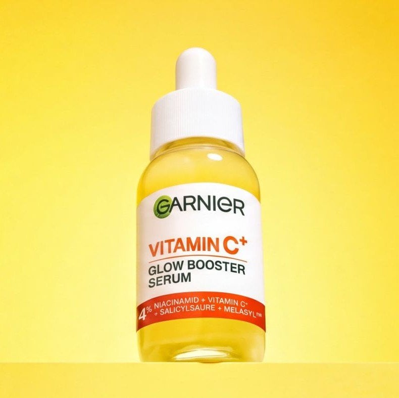 Stillleben auf einem kleinen Holztisch mit Zitronen, Vitamin C Serum Creme & Serum Maske