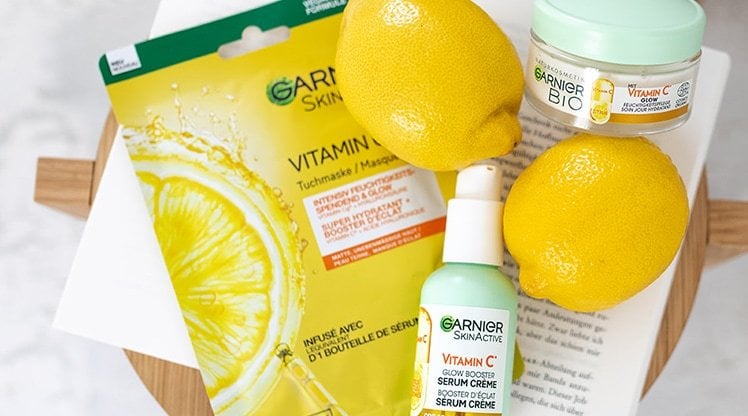 Stillleben auf einem kleinen Holztisch mit Zitronen, Vitamin C Serum Creme & Serum Maske