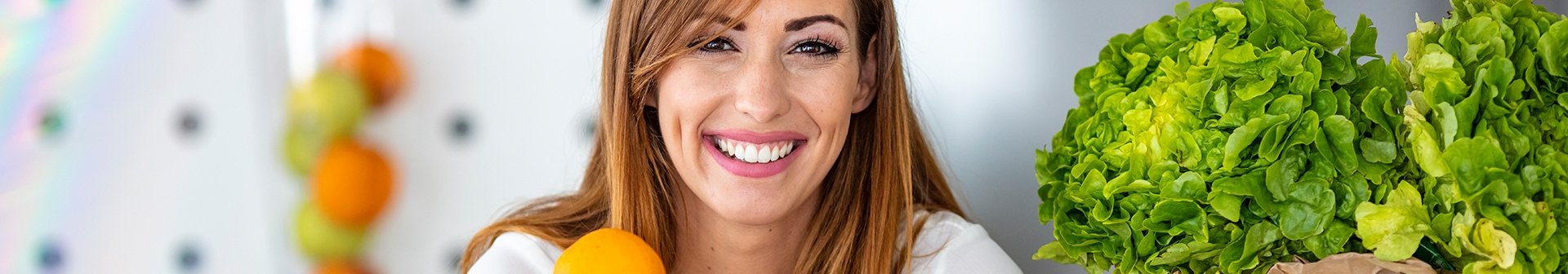 Eine lächelnde junge Frau mit einem Glas Orangensaft