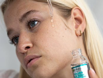 Eine Frau trägt ein Serum auf