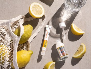 Stillleben mit Garnier Produktabbildungen Zitronen und einem Glas Wasser