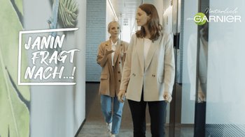 Zwei Frauen gehen durch ein Bürogebäude