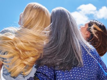 Eine blonde und eine grauhaarige Frau von hinten