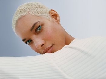 Bild einer Frau mit platinblonden Haaren, die in die Kamera schaut