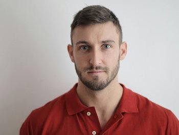 Mann mit kurzen Haaren und rotem Polo-Hemd