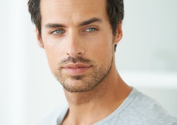 Dunkelhaariger Mann mit ersten grauen Haaren, der nach links schau