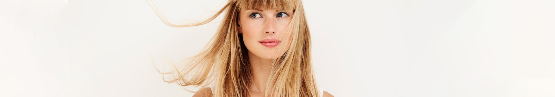 Frau mit langen, mittelblonden Haaren, die leicht im Wind wehen