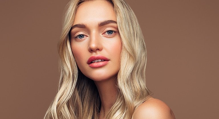 Junge Frau mit langen hellblonden, gewellten Haaren