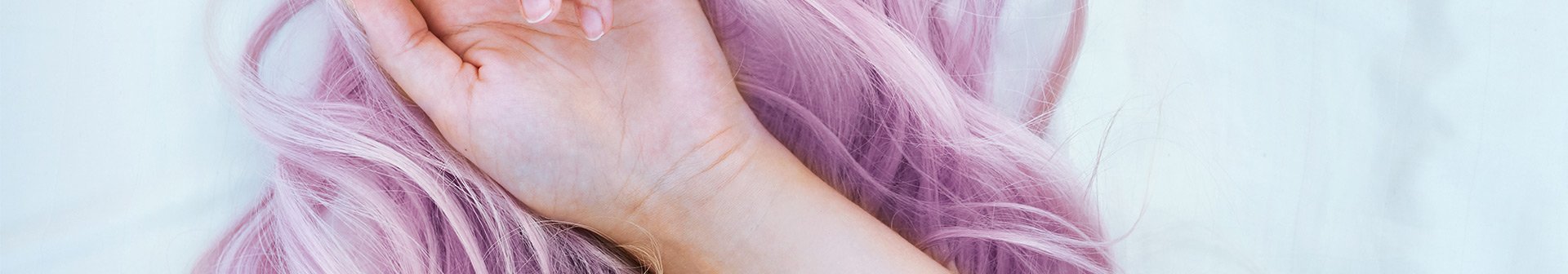 Nahaufnahme einer Hand auf violetten Haaren