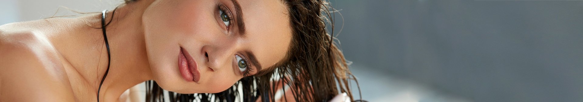 Junge Frau wendet Pflegespülung an