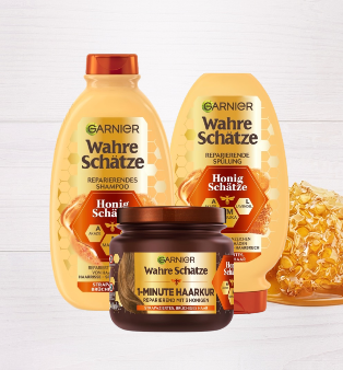 Wahre Schätze Reparierendes Shampoo Honig Schätze in der Hand einer Frau vor einem orangebraunen Hintergrund